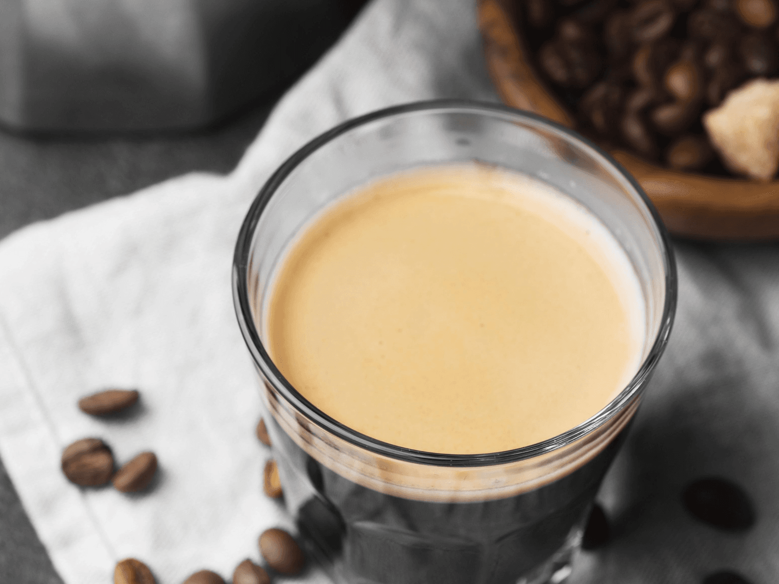 An espresso pull with freshly ground beans as the machine makes a drink